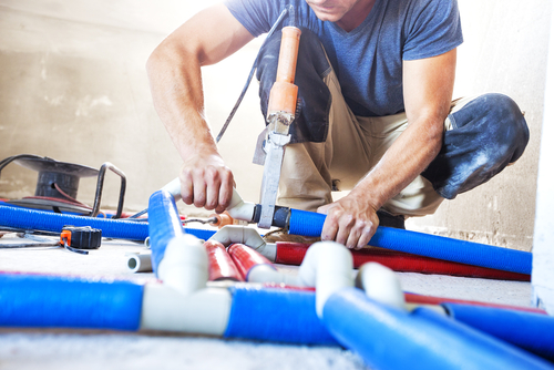 Plumber working on residential water supply pipe replacement